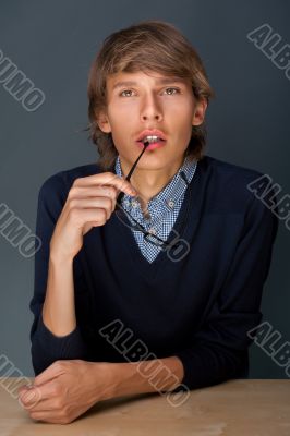 Portrait of a handsome young business man leaning against the wa