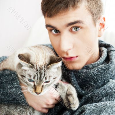 Relaxed man sitting on armchair holding and petting pet cat