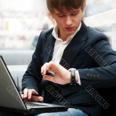 Portrait of handsome young man working with laptop at cafe at bu