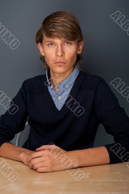 Portrait of a young satisfied casual business man. Hands on tabl