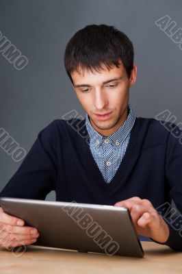 Closeup of a young smiling business man sitting at his office ag