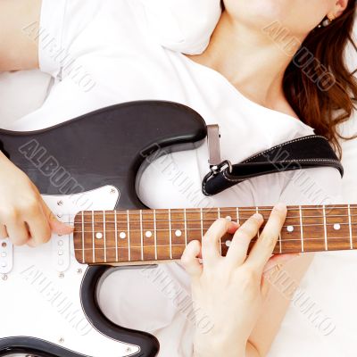 Teen girl holding a guitar like a rock star and enjoying playing
