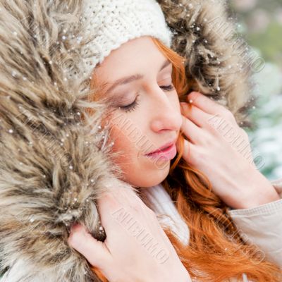 Portrait of pretty girl at winter background wearing warm clothe