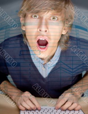 Portrait of young handsome shocked good looking man working usin