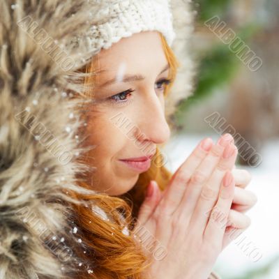 Portrait of pretty girl at winter background wearing warm clothe