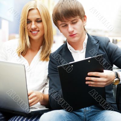 Two students working on their college project at hall using lapt