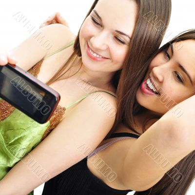 Two women shooting themselves on cell phone camera and smiling