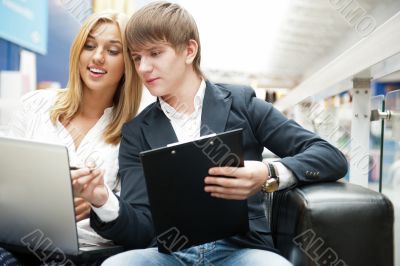 Two students working on their college project at hall using lapt