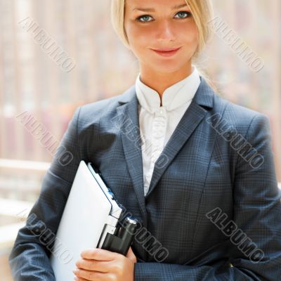 Portrait of a cute business woman with her laptop inside office 