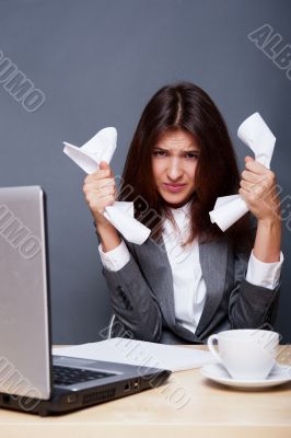 A depressed woman holding in her hands crumpled paper. Sitting a