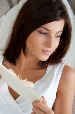 Delighted woman reading a valentine greeting card with heart and