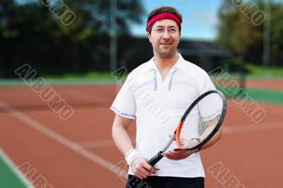 Mature man playing tennis at his backyard of his house