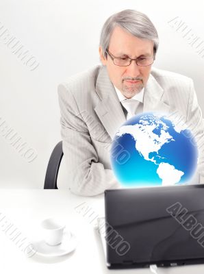 Portrait of an older businessman with a computer and a cup.