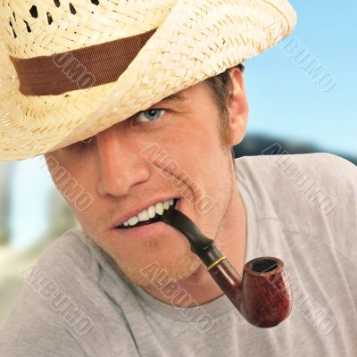 Closeup of a happy brutal young man looking at camera and smokin