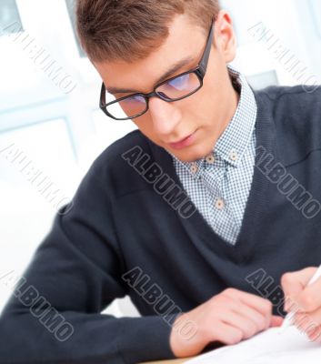High school - Young male student write notes in classroom