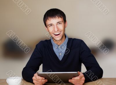 Closeup of a young smiling business man sitting at his living ro