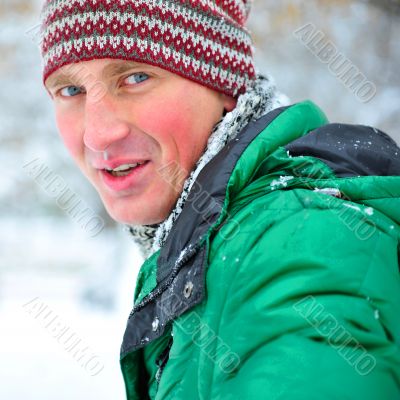 Satisfied smiling businessman standing in the green outdoors