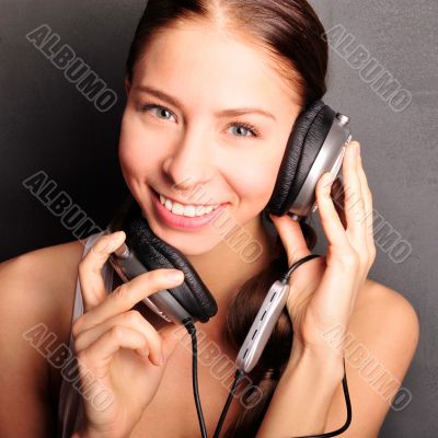 Club style woman with headphones listening to music looking at c