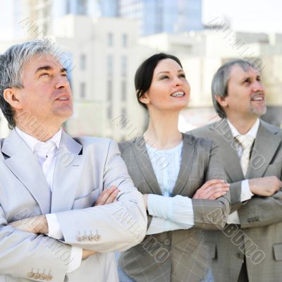 Portrait of three business people outside.