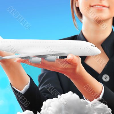 Portrait of young happy woman stewardess holding jet aircraft in