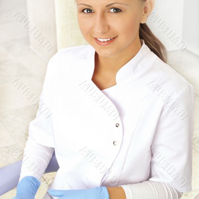 woman dentist at her office smiling wearing formal medical suit