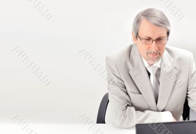 Portrait of an older businessman with a computer and a cup.