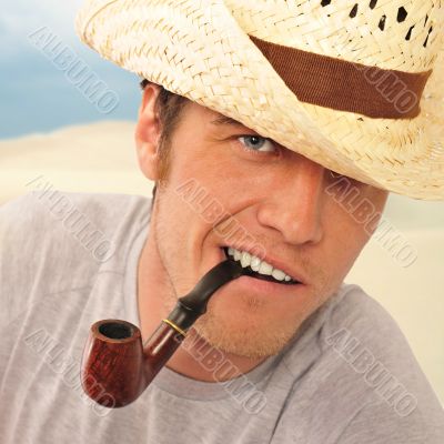 Closeup of a happy brutal young man looking at camera and smokin