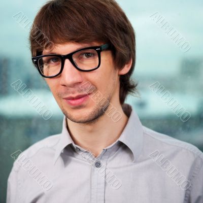 Closeup of a young smiling business man standing against big win