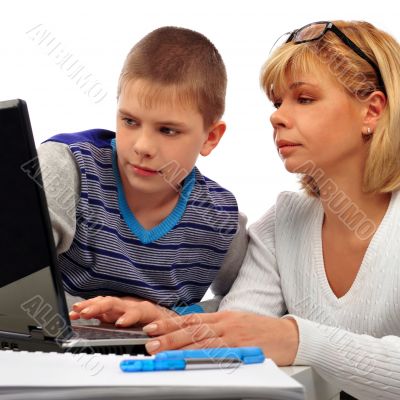 Portrait of adult woman watching as her son doing homework