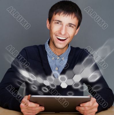 Closeup of a young smiling business man sitting at his office ag