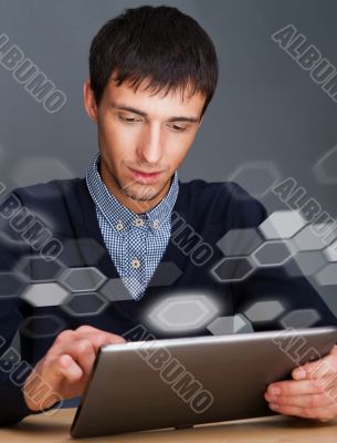 Closeup of a young smiling business man sitting at his office ag