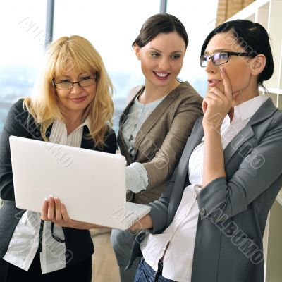 Closeup portrait of three women working indoor together with doc