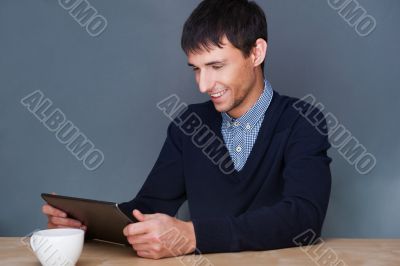 Closeup of a young smiling business man sitting at his office ag