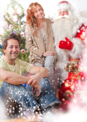 Happy family embracing and sitting on the floor in front of Chri Happy family embracing and sitting on the floor in front of Chri