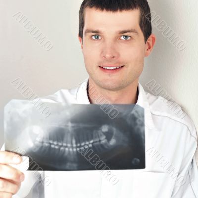 Portrait of smiling caucasian man doctor wearing uniform standin