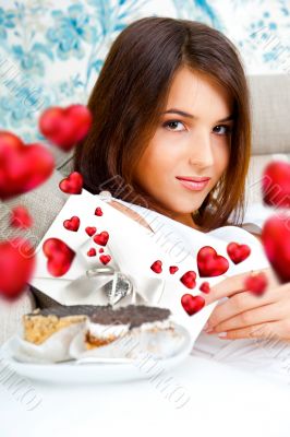 Delighted woman reading a greeting card sitting on the sofa at h