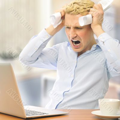Image of young employer touching his head in frustration and cry
