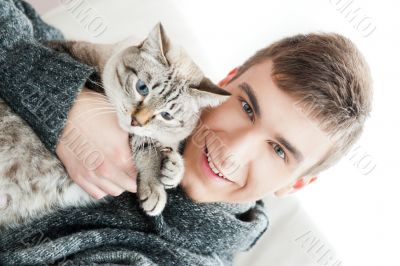 Relaxed man sitting on armchair holding and petting pet cat Relaxed man sitting on armchair holding and petting pet cat