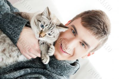 Relaxed man sitting on armchair holding and petting pet cat