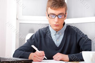 High school - Young male student write notes in classroom