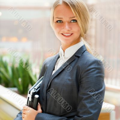 Portrait of a cute business woman with her laptop inside office 