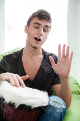 Happy young handsome man at home, smiling and playing arabic tra