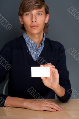 Portrait of young handsome business man holding blank white busi