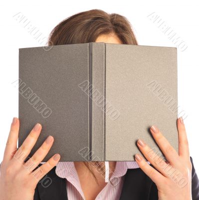 Young smiling student woman hiding under book. Over white backgr