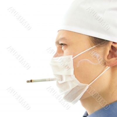 Portrait of young doctor wearing uniform smoking through the bre Portrait of young doctor wearing uniform smoking through the bre