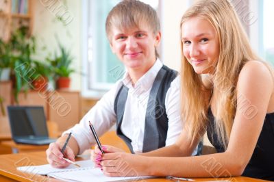 Portrait of college students working indoors looking happy