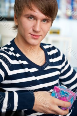 Portrait of young man inside shopping mall sitting relaxed on co