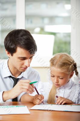 Teacher helping elementary school pupils with their tasks