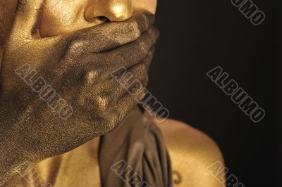 Portrait of young sexy woman in golden paint 