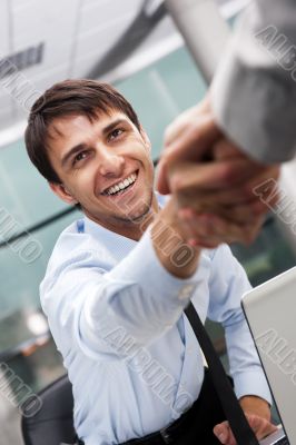 Closeup of business people shaking hands over a deal at office -